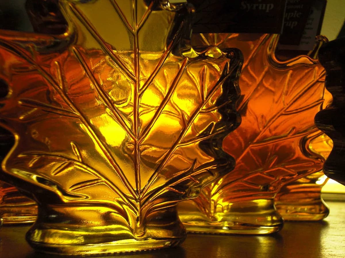 Amber maple syrup in maple leaf shaped glass bottles