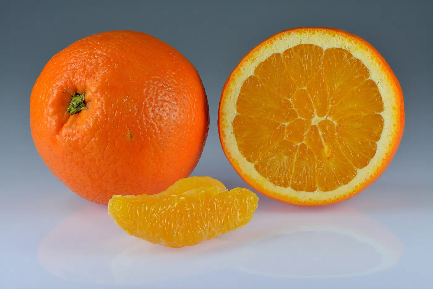 Whole and sliced sweet oranges with bright orange peel