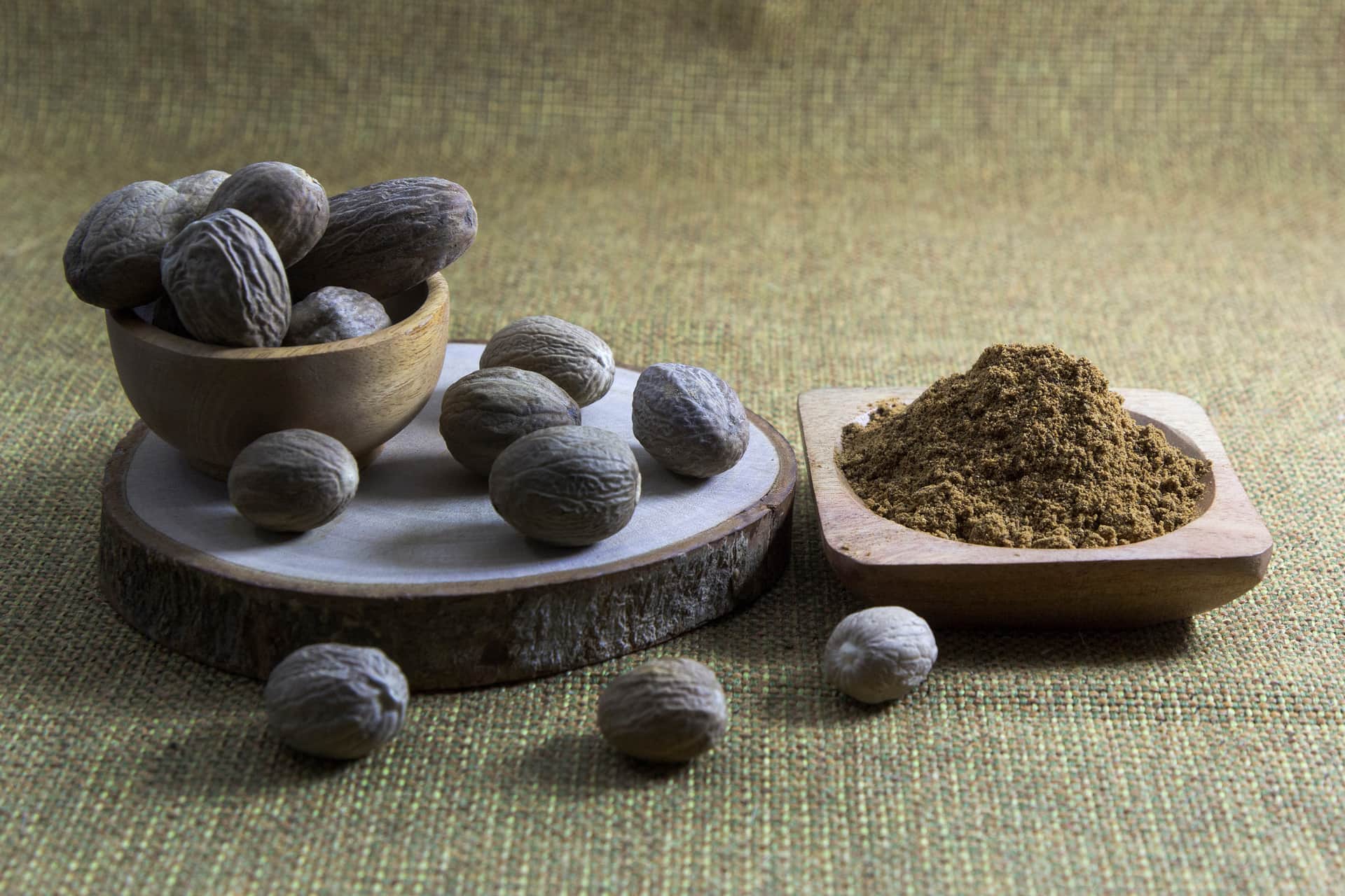 Whole and cracked nutmeg seeds with mace