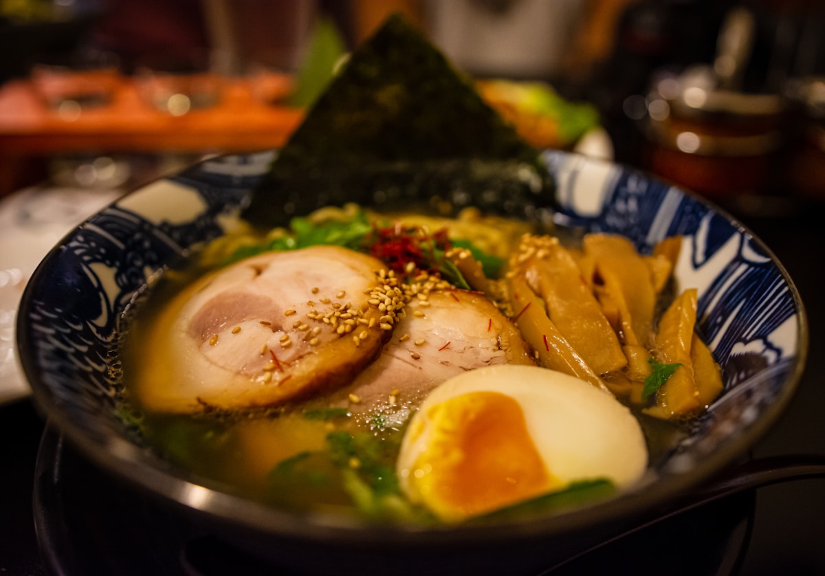 A steaming bowl of ramen with noodles, egg, and broth