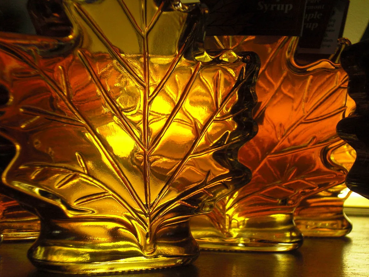 Amber maple syrup in maple leaf shaped glass bottles