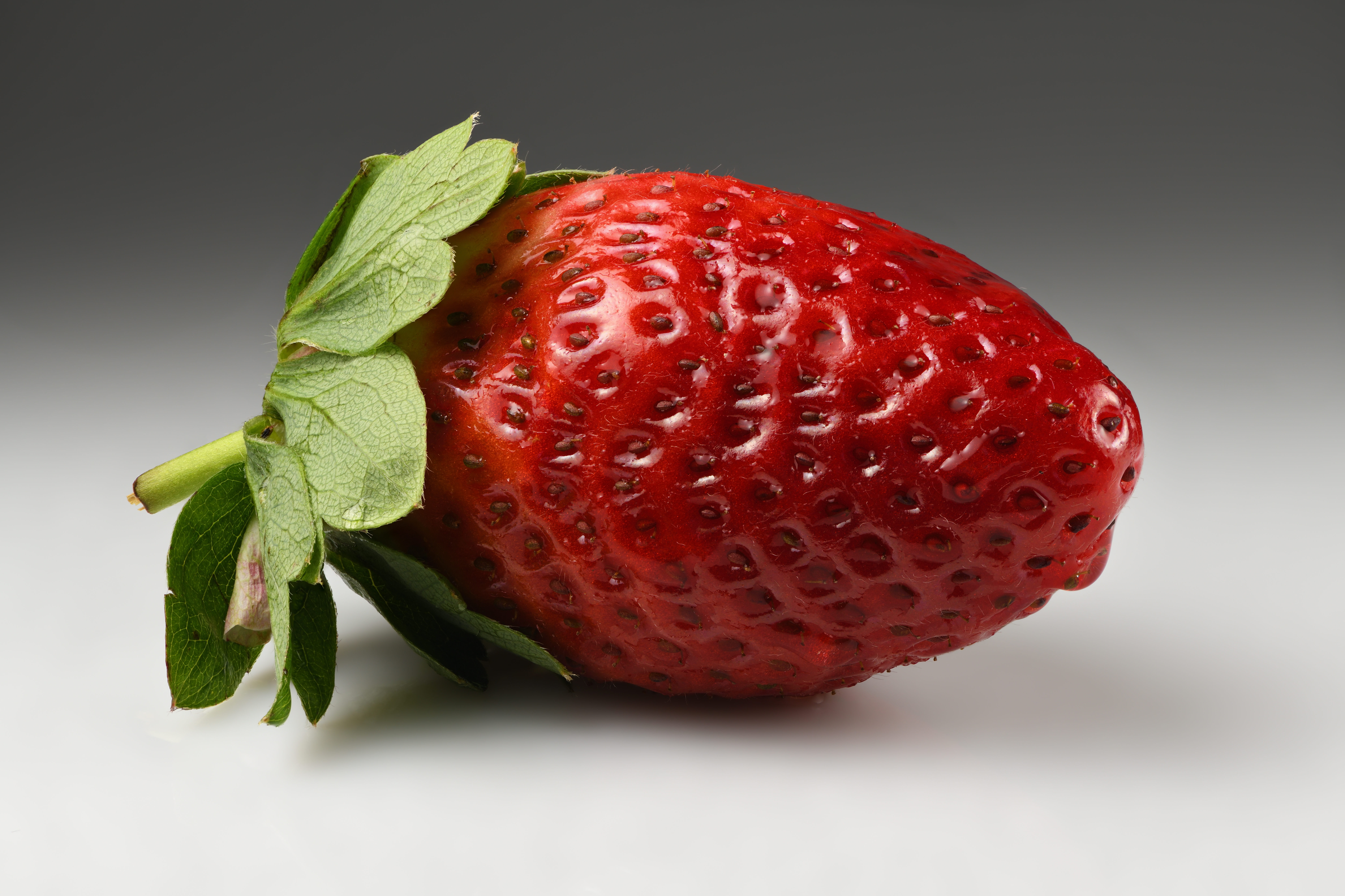 Ripe red garden strawberry with green leaves