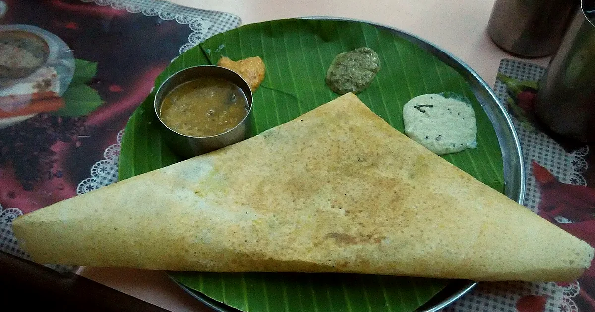 Soft white idli rice cakes with coconut chutney and sambar on a metal plate